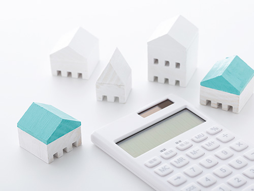 家の模型と電卓の画像